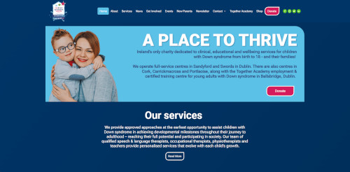A woman holding a child with Down syndrome, both smiling at the camera, with a website banner text above them stating 'A Place To Thrive' and information about services for children with Down syndrome.