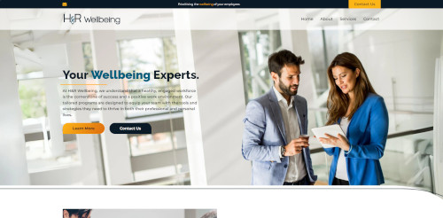 Two professionals discussing information on a tablet in a modern office setting, with a large banner reading 'Your Wellbeing Experts' on the background. The setting appears bright and contemporary.