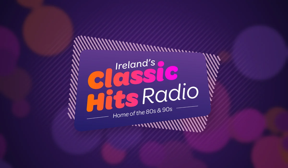A purple promotional graphic for Ireland’s Classic Hits Radio, with a tilted logo panel centered over a blurred bokeh background.